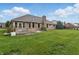 Back exterior featuring brick facade and large grassy backyard at 105 Meadowview Ln, Greenwood, IN 46142
