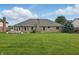 Backyard view highlighting a large brick home and lush lawn at 105 Meadowview Ln, Greenwood, IN 46142