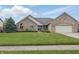 Charming brick home featuring a well-manicured lawn, lush greenery, and an attached two-car garage at 105 Meadowview Ln, Greenwood, IN 46142