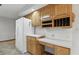 Kitchen area with wood cabinets, white countertops, wine wrack and white appliances at 105 Meadowview Ln, Greenwood, IN 46142