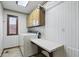 Laundry room with striped wallpaper, tile flooring, front-load washer, dryer and folding table at 105 Meadowview Ln, Greenwood, IN 46142