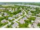 Aerial view showcasing a community with homes, mature trees, manicured lawns, and a nearby lake at 10784 Giselle Way, Fishers, IN 46040