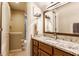 Bathroom with granite countertops, modern sink and vanity with hardwood cabinets and a framed mirror, plus tile flooring at 10784 Giselle Way, Fishers, IN 46040