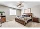 This primary bedroom features neutral paint, a ceiling fan, carpet flooring and great natural light from a nearby window at 10784 Giselle Way, Fishers, IN 46040