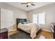 This primary bedroom features hardwood flooring, neutral paint, a ceiling fan, a window and a big bed and nightstand at 10784 Giselle Way, Fishers, IN 46040