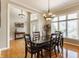 Elegant dining room with hardwood floors, stylish lighting, and a large window with backyard views at 10784 Giselle Way, Fishers, IN 46040