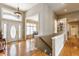 Bright foyer with hardwood floors, staircase, white trim, wainscoting and lots of natural light from the door and transom at 10784 Giselle Way, Fishers, IN 46040