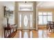 Inviting foyer featuring hardwood floors, a decorative front door, and ample natural light at 10784 Giselle Way, Fishers, IN 46040