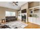 Comfortable living room with a fireplace, built-in shelving, and a vaulted ceiling at 10784 Giselle Way, Fishers, IN 46040