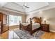Serene main bedroom with tray ceilings, a ceiling fan, hardwood floors, and large windows at 10784 Giselle Way, Fishers, IN 46040