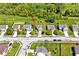 An aerial view captures the home's location, highlighting a manicured lawn and the proximity to a lush green wooded area at 10876 Trailwood Dr, Fishers, IN 46038