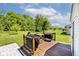 Backyard featuring a wooden deck with grill, outdoor furniture, lush green lawn, and mature trees at 10876 Trailwood Dr, Fishers, IN 46038