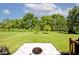 Well-kept backyard with green lawn, mature trees, landscaping, and a stone patio with a fire pit at 10876 Trailwood Dr, Fishers, IN 46038