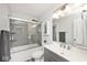 Modern bathroom featuring a shower over tub, glass screen, white sink and vanity with silver hardware at 10876 Trailwood Dr, Fishers, IN 46038