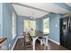 Bright dining room with dark wood floors and a rustic wood table, bathed in natural light at 10876 Trailwood Dr, Fishers, IN 46038