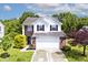 Charming two-story home with brick and white siding, lush green lawn, and a two car garage at 10876 Trailwood Dr, Fishers, IN 46038