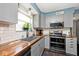 Modern kitchen with gray cabinets, butcher block countertops, and stainless steel appliances at 10876 Trailwood Dr, Fishers, IN 46038