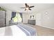 Inviting main bedroom featuring a ceiling fan, dresser, large window, and plush carpeting at 10876 Trailwood Dr, Fishers, IN 46038