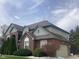 Well-maintained home shows siding and brick with mature landscaping and attached garage at 11458 Sutton Place W Dr, Carmel, IN 46032