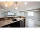 Basement bar area with granite countertops, stainless steel appliances, and an adjacent entertainment space at 12600 Misty Ridge Ct, Fishers, IN 46037