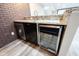 Basement bar featuring a granite counter, wine fridge, stainless steel sink and a brick accent wall at 12600 Misty Ridge Ct, Fishers, IN 46037