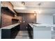 Close up of basement bar with brick backsplash, granite countertops, and black cabinets at 12600 Misty Ridge Ct, Fishers, IN 46037