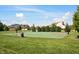 Outdoor basketball court surrounded by green grass and trees, providing a recreational space for sports and exercise at 12600 Misty Ridge Ct, Fishers, IN 46037