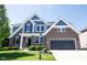 Charming brick and blue home exterior with a well-maintained lawn and an attached garage at 12600 Misty Ridge Ct, Fishers, IN 46037