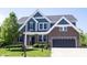 Beautiful two-story brick and blue home with a well-manicured lawn and attached two-car garage at 12600 Misty Ridge Ct, Fishers, IN 46037
