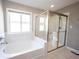 Main bathroom featuring a soaking tub with tile surround and a glass-enclosed shower at 12600 Misty Ridge Ct, Fishers, IN 46037