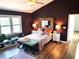 Bedroom featuring plum colored walls, hardwood floors, a large decorative mirror, and a luxurious bed at 13497 Dunes Dr, Carmel, IN 46032