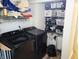 Functional laundry room with shelving, storage baskets, and modern black washer and dryer at 13497 Dunes Dr, Carmel, IN 46032