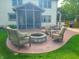 Inviting patio with a stone fire pit, comfortable seating, and a screened-in porch, ideal for outdoor entertaining at 13497 Dunes Dr, Carmel, IN 46032
