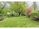 Secluded backyard with lush lawn, mature trees, and landscaping surrounding the property at 140 Meridian Hills Blvd, Indianapolis, IN 46260