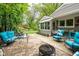 Backyard patio area with comfortable seating, a grill, and lush landscaping including mature trees at 140 Meridian Hills Blvd, Indianapolis, IN 46260