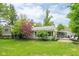 A view of the home's backyard featuring a patio area, lush lawn, and mature trees at 140 Meridian Hills Blvd, Indianapolis, IN 46260