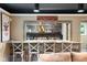 Finished basement wet bar with wooden accents, stone countertop, shelving, and seating for four at 140 Meridian Hills Blvd, Indianapolis, IN 46260