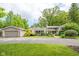 Well-maintained home with a detached garage and a lush, green lawn, offering curb appeal at 140 Meridian Hills Blvd, Indianapolis, IN 46260