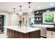 Open concept kitchen with island, stainless appliances, and access to outdoor patio at 140 Meridian Hills Blvd, Indianapolis, IN 46260