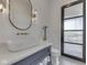 Stylish powder room with a vessel sink, decorative mirror, and modern lighting fixtures at 14464 Gainesway Cir, Fishers, IN 46040