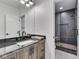Modern bathroom with granite countertop, well-lit vanity area, and a separate shower featuring tiled walls and flooring at 14464 Gainesway Cir, Fishers, IN 46040