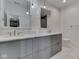 Stylish bathroom with double sinks, white countertops, gray cabinets, and unique mirrors at 14464 Gainesway Cir, Fishers, IN 46040