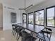 Modern dining room with sleek table, black chairs, and a view of the pool and community amenities at 14464 Gainesway Cir, Fishers, IN 46040
