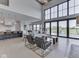 Open-concept living room boasts a soaring ceiling, floor-to-ceiling windows with lake views, and stylish modern furniture at 14464 Gainesway Cir, Fishers, IN 46040
