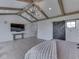 The primary bedroom boasts vaulted ceilings, exposed wood beams, and a mounted television at 14464 Gainesway Cir, Fishers, IN 46040