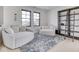 This sitting room features two chairs, windows, light hardwood floors, and a metal decorative shelving unit at 14464 Gainesway Cir, Fishers, IN 46040