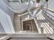 Unique staircase with light wood stairs and dark railing, features modern chandelier above, providing a modern view at 14464 Gainesway Cir, Fishers, IN 46040