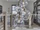Modern staircase landing with an array of unique lighting fixture and contemporary railing, creating a modern, airy aesthetic at 14464 Gainesway Cir, Fishers, IN 46040