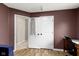 A room with brown walls features an ironing board behind a set of doors at 14542 Baldwin Ln, Carmel, IN 46032