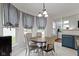 Inviting breakfast nook with a round table, four chairs, and natural light from surrounding windows at 14542 Baldwin Ln, Carmel, IN 46032